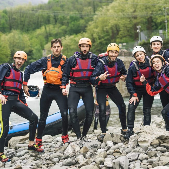 Group of playful friends at a rafting class posing at boat